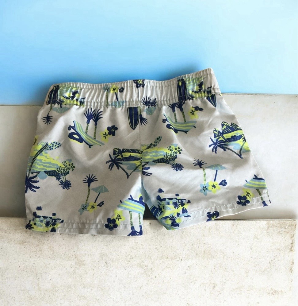 Light blue swim shorts with tropical print and elastic waist